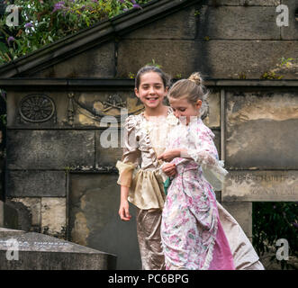 Edinburgh Fringe Festival, Henry Box Brown: Musical Journey photocall, 1st August 2018. Edinburgh, Scotland, UK. The cast at Abraham Lincoln Memorial, Old Calton Burial Ground, which commemorates the  Scots who fought on behalf of the Union in America. Ben Harney and writer Mehr Mansuri create the musical about a 1850s Virginia slave who ships himself to freedom in a box. Two young girls in 19th century costume in the graveyard Stock Photo