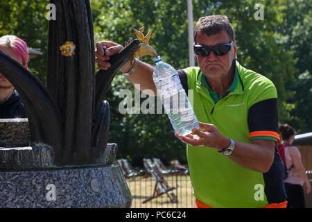 Green Park. London. UK 1 Aug 2018 - A man fill water bottles from the drinking fountain in Green Park on a sunny and warm day in the capital. According to The Met Office the heatwave is to return after a brief drop in temperature and rainfall in the UK as 32 degrees celsius is forecasted for the coming weekend.   Credit: Dinendra Haria/Alamy Live News Stock Photo