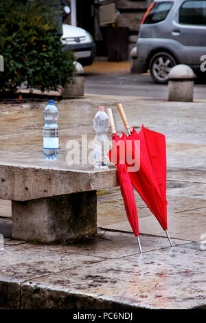 Two red umbrellas on rainy street left Stock Photo