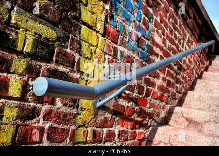 Old metal handrail on a wall with graffiti and the stairs Stock Photo
