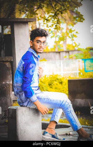 Indian male model posing for the photo while sitting on the land Stock Photo  | Adobe Stock