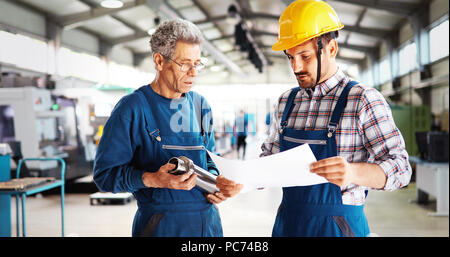 Team Of Engineers Having Discussion In Factory Stock Photo