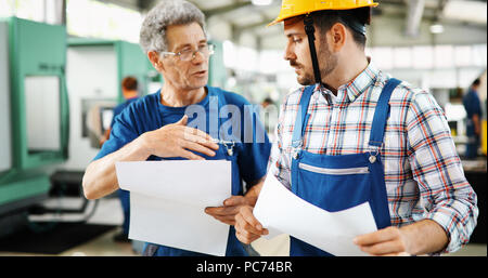 Engineer Teaching Apprentices To Use Computerized cnc metal processing machines Stock Photo
