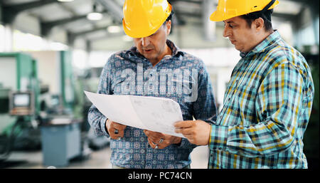 Team Of Engineers Having Discussion In Factory Stock Photo