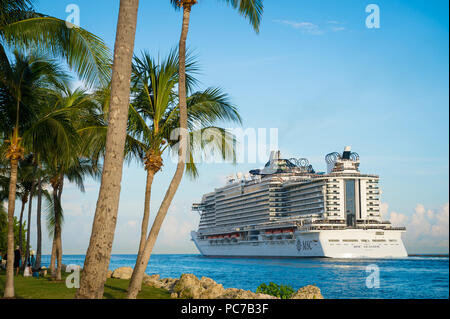 MIAMI - CIRCA JUNE, 2018: MSC Seaside cruise ship passes South Beach palm trees as it leaves port. Stock Photo