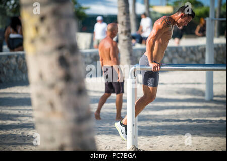 MIAMI - CIRCA JUNE, 2018: Muscular young men work out in the outdoor gym known as Muscle Beach in Lummus Park. Stock Photo