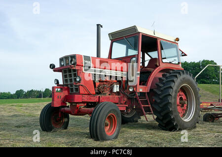 International Harvester model 1466 diesel Row Crop tractor in hay field Stock Photo