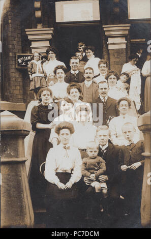 Vintage Photograph of Smartly Dressed People Posing on The Steps of Apartments, Most Likely To Be a Seaside Boarding House. Stock Photo