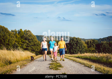 Family walking their dog on a dirt path