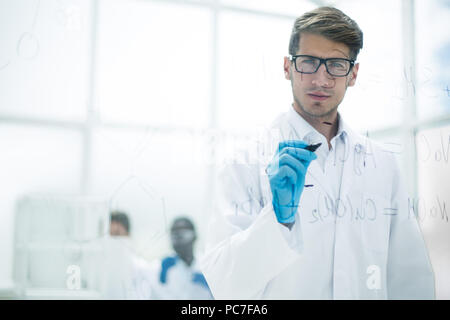scientist making notes on the glass Board at the time of the experiment Stock Photo