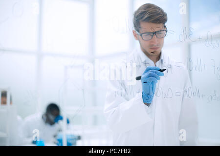 scientist making notes on the glass Board at the time of the experiment Stock Photo