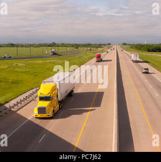 An 18-wheeler semi-trailer truck rides on the Mexico side of the border ...