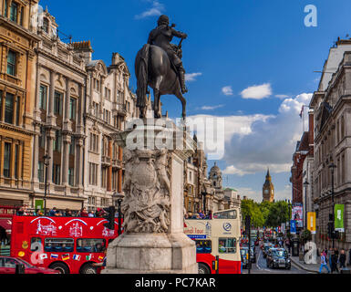 View from Trafalgar Square past statue of Charles I with tourists tour travel bus and taxis Whitehall Parliament & Big Ben, Westminster, London, UK Stock Photo