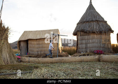 Small boy running around on Las Islas Flotantes (floating islands made of totora reeds). Lake Titicaca. Puno, Peru. Jun 2018 Stock Photo