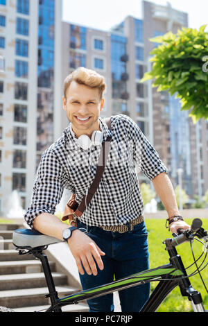 Joyful positive man using his bicycle Stock Photo