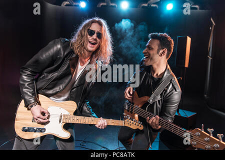 Electric guitar players performing hard rock music on stage Stock Photo