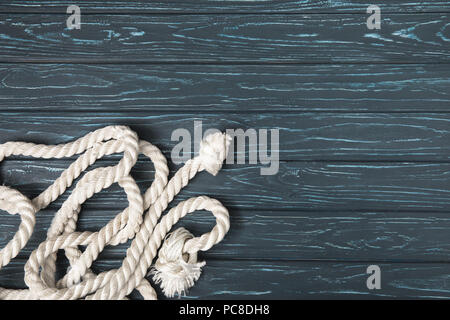 top view of knotted white nautical rope on wooden planks Stock Photo