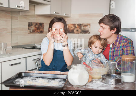 young family preparing homemade cookies in shape of hearts Stock Photo