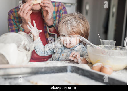 father and child having fun with flour at kitchen Stock Photo
