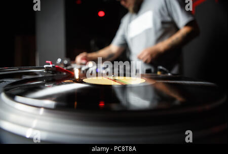 Club DJ mixing vinyl records in blue stage lights. Close up photo of disc  jockey playing music on party in night club Stock Photo - Alamy
