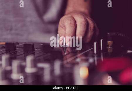 Professional hip hop dj mixes tracks with sound mixer console on concert in night club Stock Photo