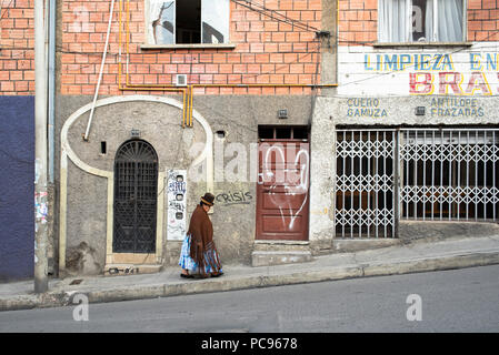 Indigenous Cholita wearing typical Bolivian clothing: bowler hat, la manta (thick shawl), la pollera (layered skirt) and flat shoes. La Paz, Bolivia Stock Photo