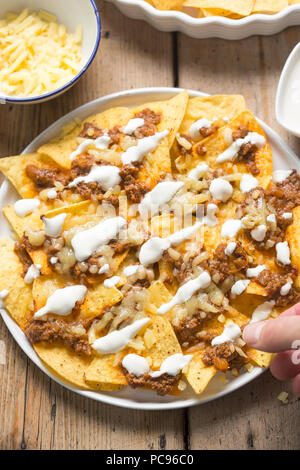Chilli beef nachos with sour cream & grated cheese Stock Photo