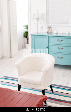 Modern interior hotel. Light apartment, comfortable room, chair and red coffee table. Stock Photo