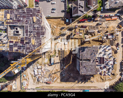 two tower cranes and other construction machines working at building site. aerial photo Stock Photo