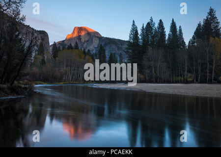 Half Dome mountain catches the last glow of sunset reflected in the Merced river in Yosemite National Park, UNESCO, California, USA, North America Stock Photo