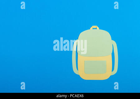 Paper cut backpack on blue background Stock Photo
