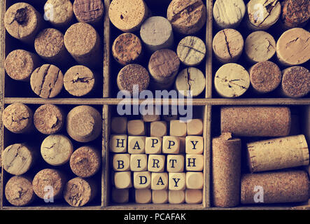 Old wooden box with bottle cork and the words Happy Birthday on small dices Stock Photo