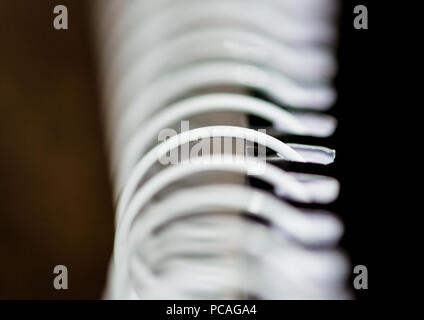 A macro shot of the metal coil binding of a notepad. Stock Photo
