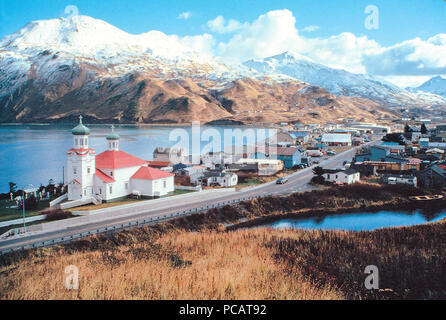 The red and green roof of a Russian-Orthodox-style church brings a spot of color to the mountainous winter landscape in this Unalaska scene. Stock Photo