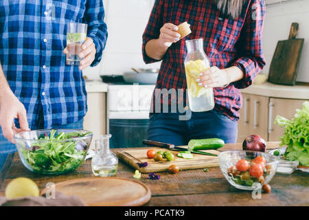 Couple is cooking healthy simple food at home in the kitchen. Healthy food concept. Couple preparing summer salad Stock Photo