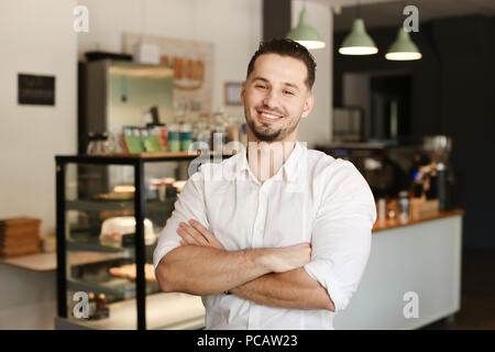 Young administrator standing with at cafe and wearing white shirt. Stock Photo