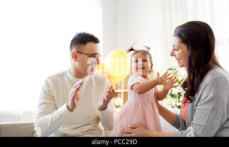 happy baby girl and parents at home birthday party Stock Photo