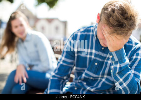 Unhappy Teenage Couple Having Argument In Urban Setting Stock Photo