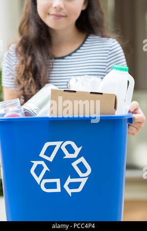 Close Up Of Teenage Girl Outside House Carrying Recycling Bin Stock Photo