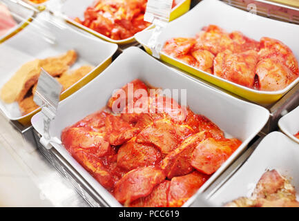 marinated meat in bowls at grocery stall Stock Photo