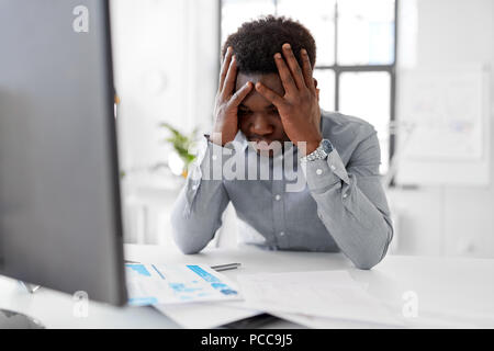 stressed businessman with papers at office Stock Photo