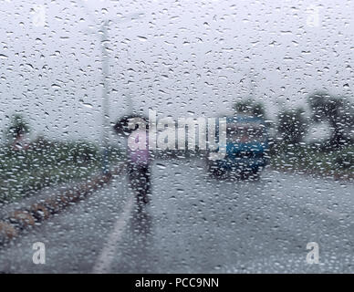 Raindrops falling on glass, abstract blurs - monsoon stock image . Stock Photo