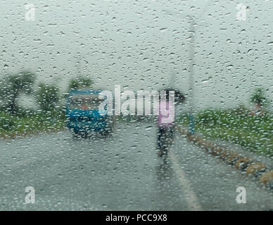 Raindrops falling on glass, abstract blurs - monsoon stock image . Stock Photo