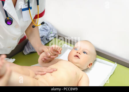 Little cute baby boy visiting doctor . Pediatrician make check up and examining infant for disease prevention protocol. Children healthcare concept Stock Photo