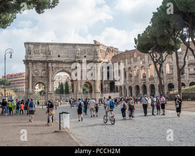 People walking around the walls and arched gate of the Colosseum, Rome, Italy Stock Photo