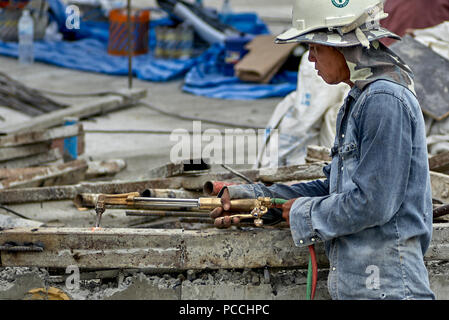 Builder using oxy acetylene torch on a construction site. Thailand Southeast Asia Stock Photo