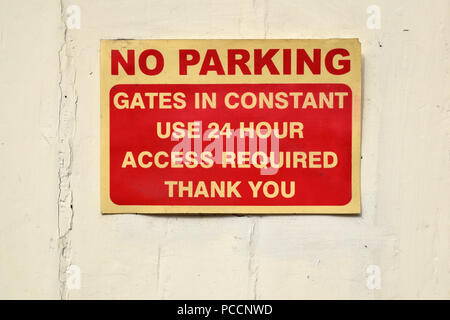No Parking Gates in constant use 24 hour access required Thank you sign red and cream white on white painted background Stock Photo