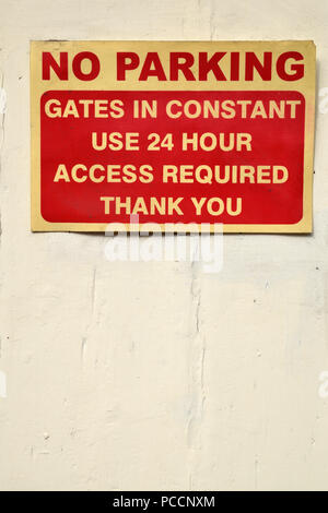 No Parking Gates in constant use 24 hour access required Thank you sign red and cream white on white painted background Stock Photo