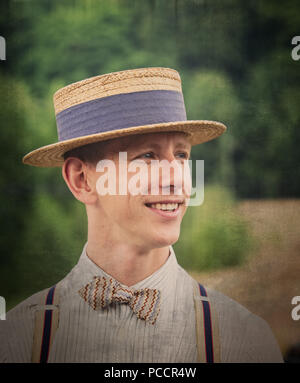 Close-up portrait of stylish young man in 1940's costume looking dapper in straw boater, bow tie & braces, Black Country Museum 1940's WWII event. Stock Photo