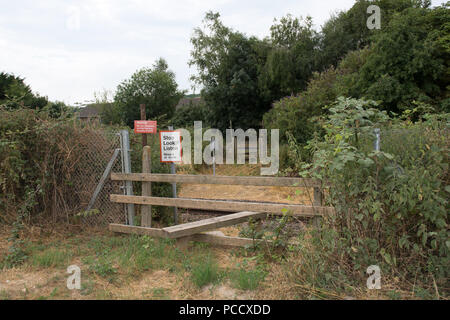 Railway crossing for pedestrians from a field Stock Photo